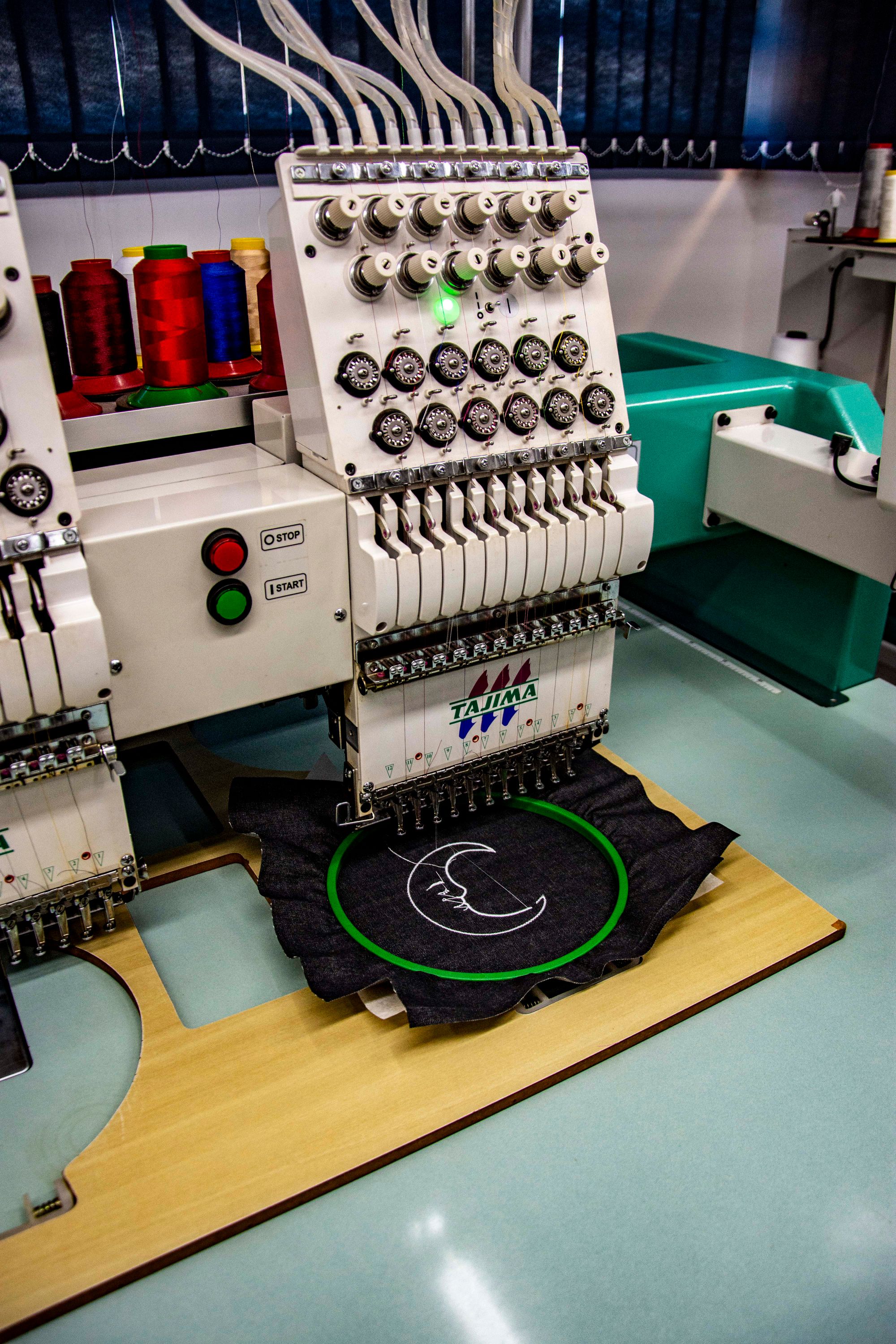 An embroidery machine stitching a motif onto hooped fabric — reference photograph